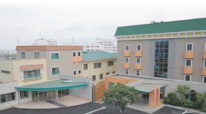 複数棟の介護施設建物群。カラフルな外壁と緑色の屋根が特徴。